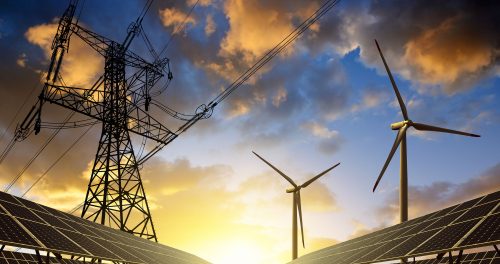 power lines and wind turbines over a solar field at sunset