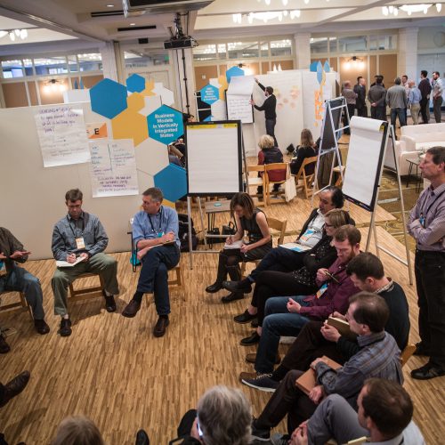 people sitting in a circle with a white board