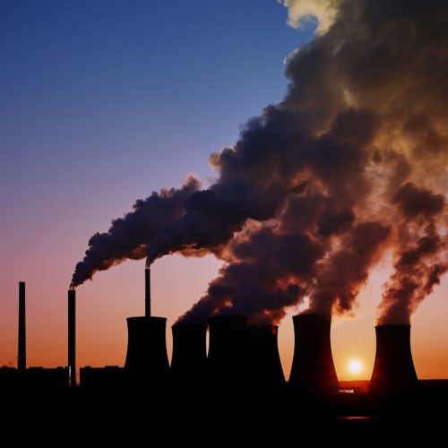 factory smoke stacks with huge clouds of expelled smoke