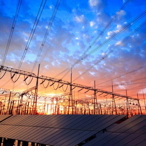 solar panels and powerlines at sunset