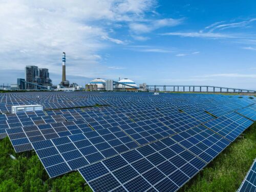 solar array field with factory in back