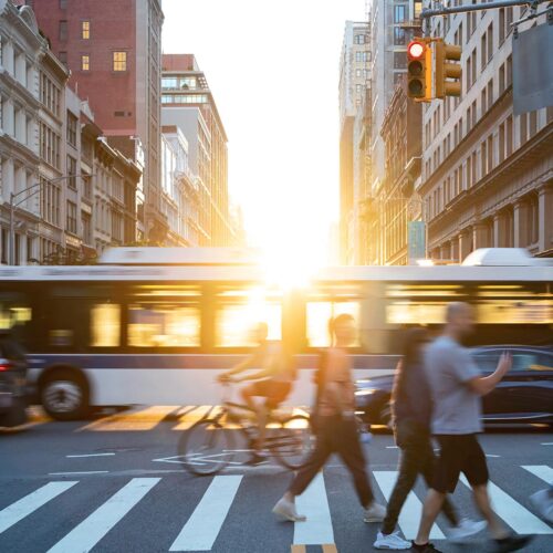 busy city crosswalk at sunset